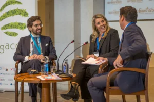 Cómo elegir un fotógrafo profesional para eventos corporativos con experiencia demostrable: mesa de debate en congreso empresarial en el Hotel Monumento San Francisco de Santiago de Compostela, con conductora sonriente y participantes atentos en un entorno profesional.