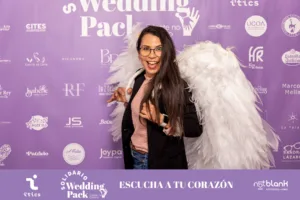 Edibel Nava, speaker para eventos, con grandes alas blancas y una sonrisa radiante en el photocall del Wedding Pack Solidario.
