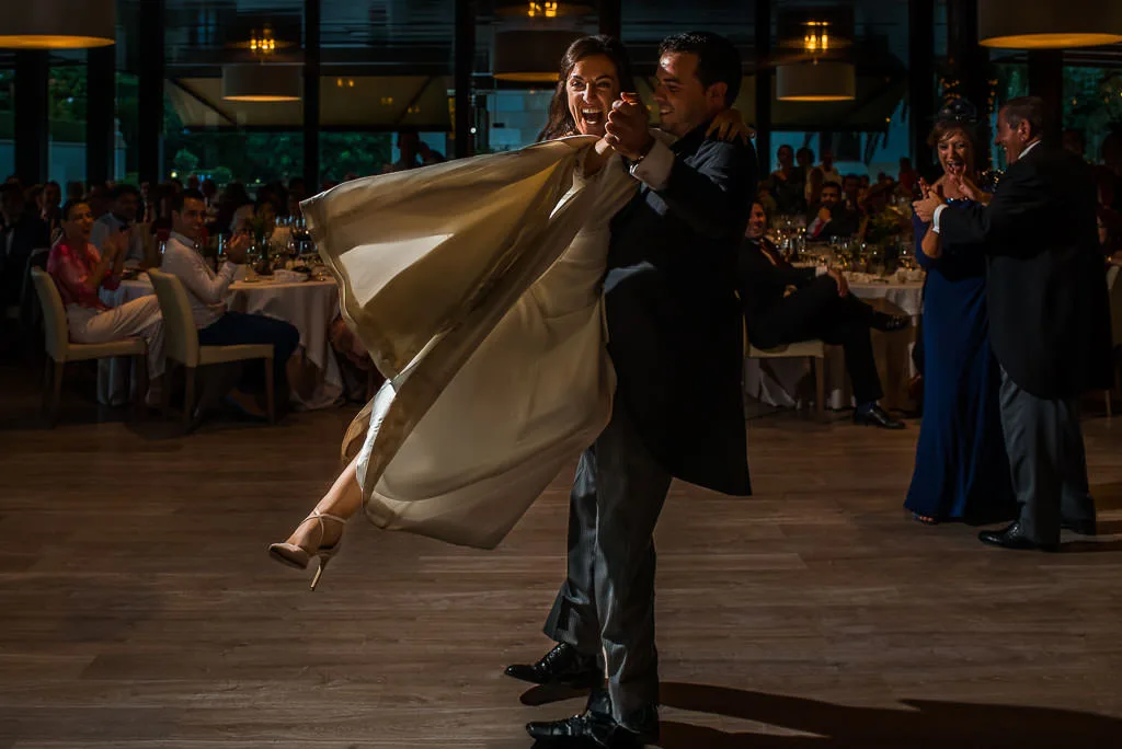 Pareja de recién casados compartiendo una mirada sincera y espontánea mientras bailan en su boda en Galicia.