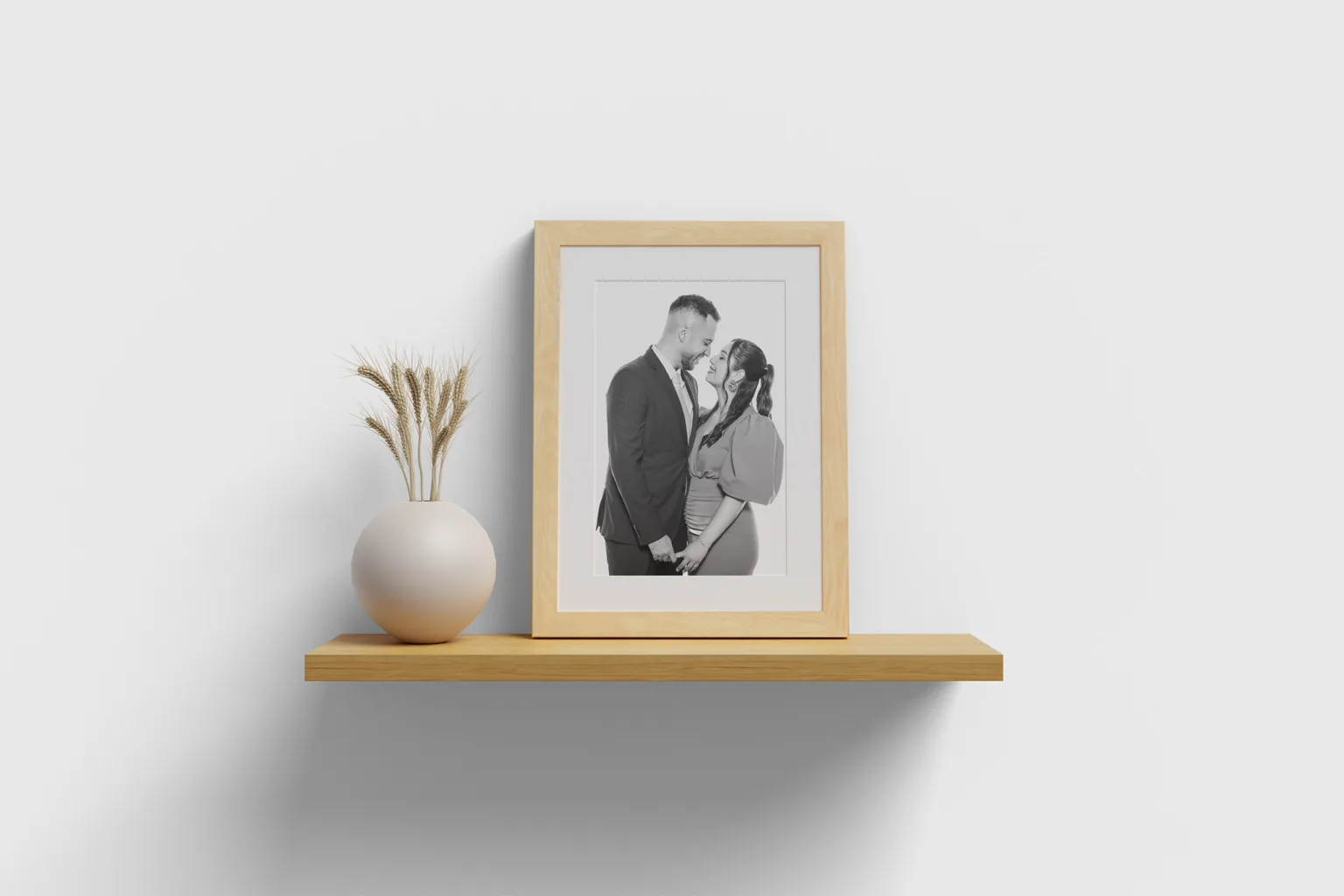 Marco de madera en una repisa en un salón con un retrato enmarcado de una pareja, capturado en la Estación de Retratos de Whitebox Portraits, representando fotos de boda que emocionan años después