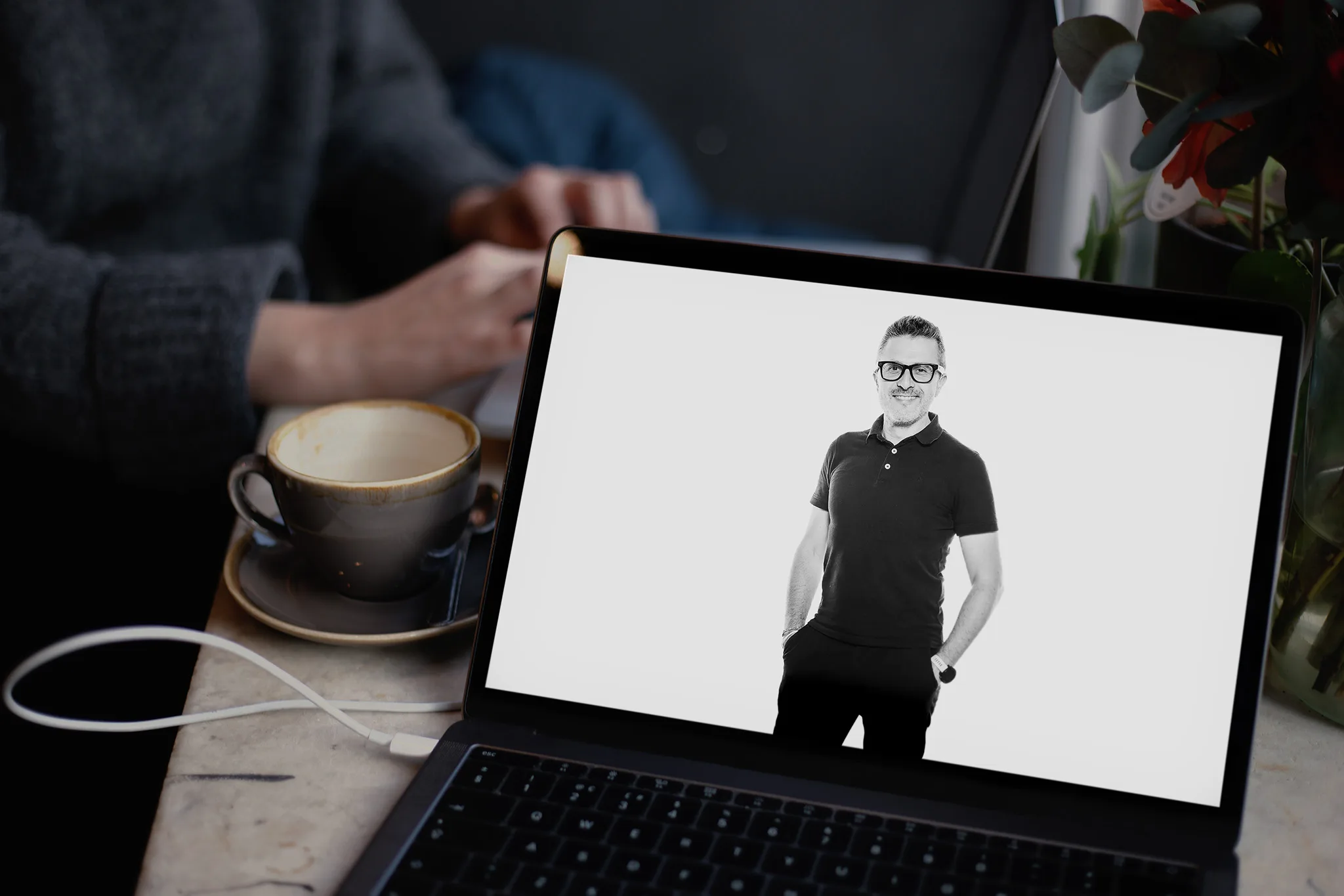 Retrato de Richard Candendo, fundador y fotógrafo de Whitebox Portraits. La foto está en la pantalla de un Macbook que está en una mesa de una cafetería.