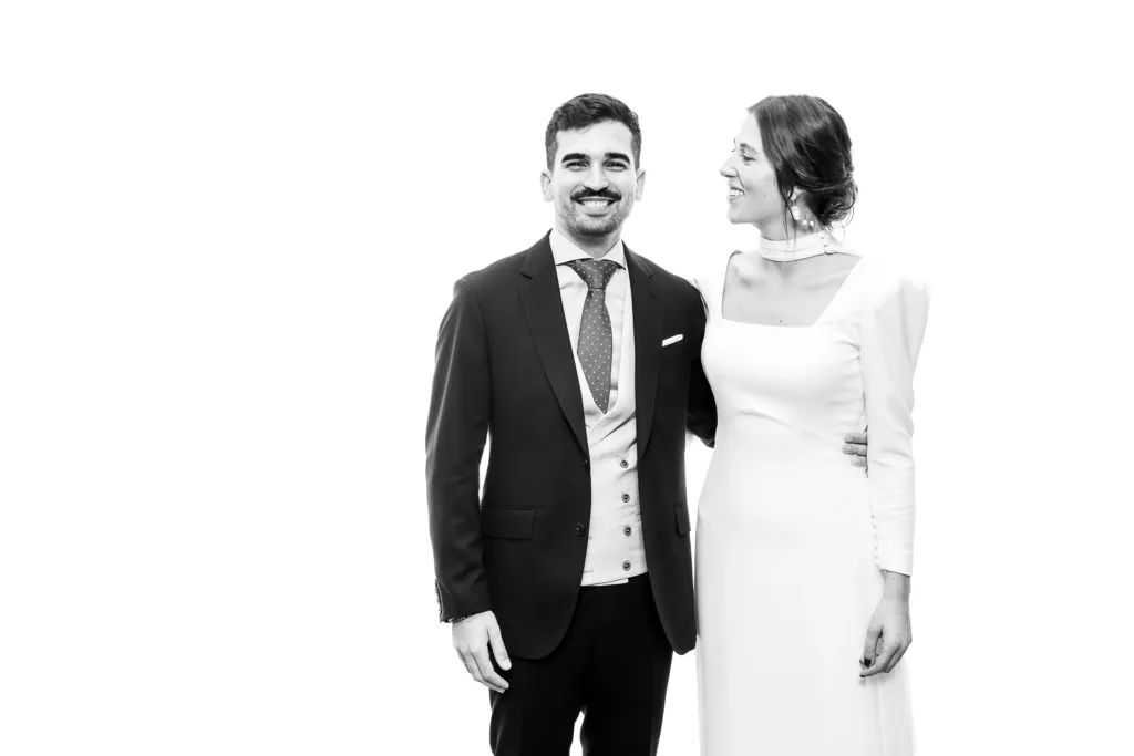 Pareja elegante de novios posando en blanco y negro, representando retratos de boda con estilo y calidad de estudio