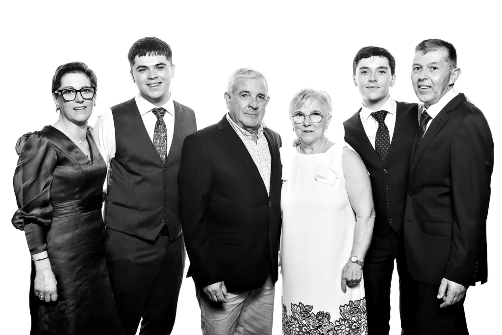 Retrato familiar multigeneracional en blanco y negro con iluminación de estudio profesional en una boda.